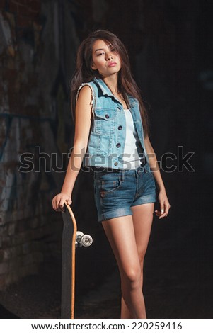  Beautiful asian teen girl with skate board. Outdoors, urban lifestyle.