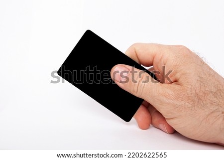 The man is holding a credit card in his hand.