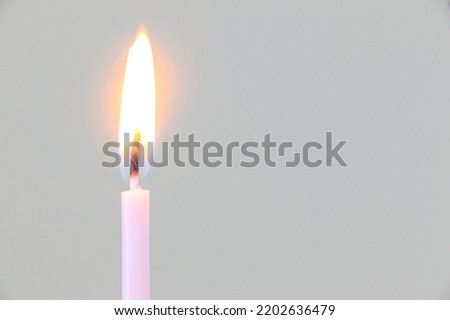 A single pink candle lit with bright flame Royalty-Free Stock Photo #2202636479