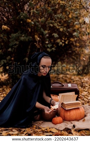 A young woman in the woods practices Halloween magic