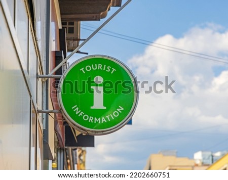 Tourist Information Illuminated Round Green Sign in Town