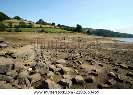 The Ladybower reservoir during a period of drought and, amongst a barren, rocky shoreline, showing a date stone and gate posts from what used to be Derwent village. Royalty-Free Stock Photo #2202663469