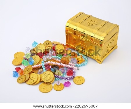 Closed treasure chest with gold colored coins on white background