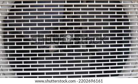 the ac cover is white with stripes with an iron fan inside