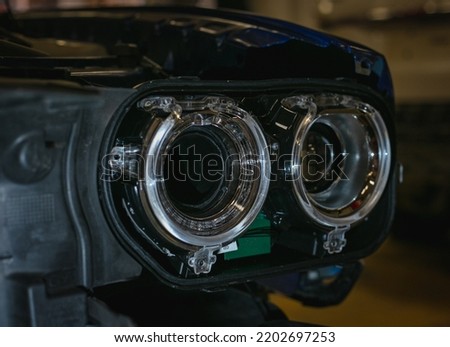 Installing the headlight on the car. Repair of car headlights. Tuning and restoration of automotive optics. Installation of the Bi LED lens in the headlight housing. Royalty-Free Stock Photo #2202697253