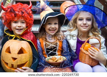 children in halloween costumes with pumpkin fooled on holiday