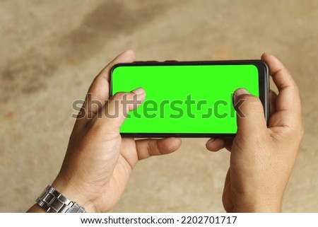 A guy is using a Smartphone and playing game , Game playing gesture, A guy is playing a game