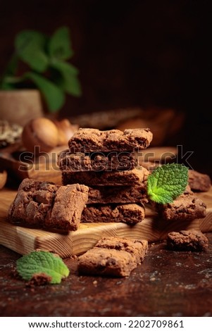 Pieces of fresh brownie with mint on an old table with kitchen utensils.