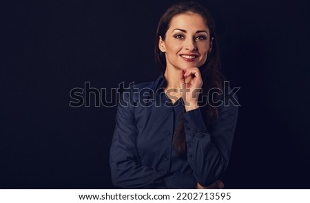 Beautiful thinking  smiling business woman with folded arms in blue shirt on black background with empty copy space for text. Closeup portrait