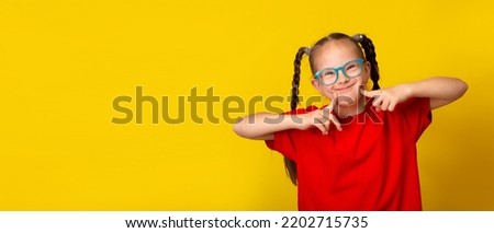 Happy girl with Down syndrome having fun and laughing in the studio. Banner Royalty-Free Stock Photo #2202715735