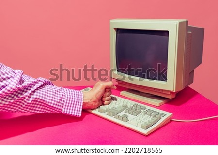 Colorful image of vintage computer monitor and keyboard isolated over bright pink background. Concept of retro pop art, vintage things, mix old and modernity. Copy space for ad