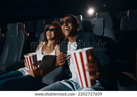A young couple came to watch a movie with popcorn. High quality photo