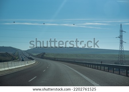 Empty highway at the sunny day with electricity line on the background
