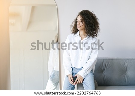 African american girl sitting at home in the living room	                               