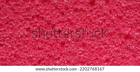 close-up, background, texture, large long horizontal banner. heterogeneous surface fine pore structure bright saturated red pumice stone for finger care. full depth of field. high resolution photo