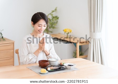 Asian woman eating a meal Royalty-Free Stock Photo #2202781911