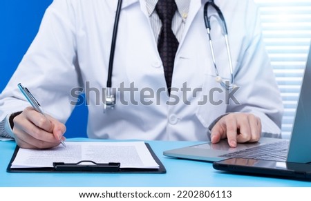 Professional Doctor sign Health care medical document of patient medicine in hospital office. Doctor wear lab coat uniform read patient chart on desk for insurance person and note pen, copy space