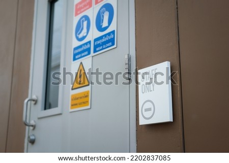 Staff only restricted area sign with safety placard icon on the metal door of swtichgear control room. Sign and symbol for industrial working place object photo, selective focus.