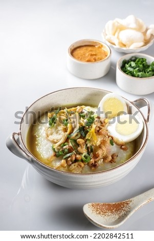 Bubur Ayam or Indonesian Rice Porridge with Shredded Chicken, cheese stick and cakwe. Royalty-Free Stock Photo #2202842511