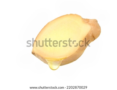 Ginger slices with essential extract oil dripping isolated on white background. Clipping path.