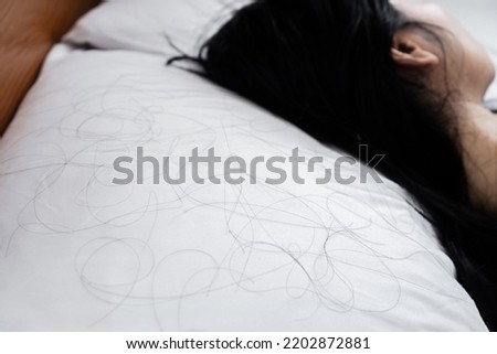 closeup hair loss fallen on pillow with blur background of woman sleeping in bed  Royalty-Free Stock Photo #2202872881