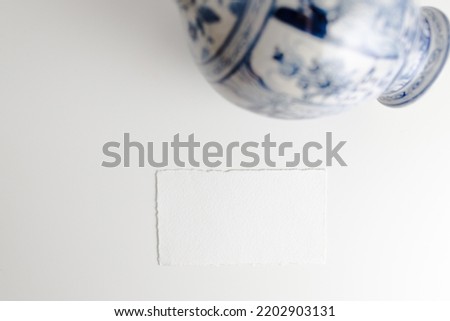 Mockup of a blank postcard with a Japanese vase next to it
