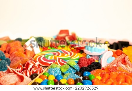 beige background with sweets, jelly beans, marshmallows, marshmallows, clouds, candies, hearts, leaving a space for the text.