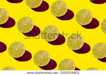 Lime pattern on a yellow background. Pop art design, creative citruses. Yellow lemon, minimal flat style. High quality photo