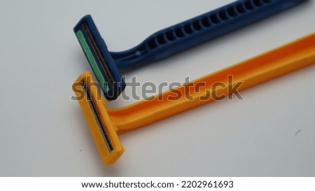 Disposable yellow and blue razors put together on white background. Bekasi, 17 september 2022