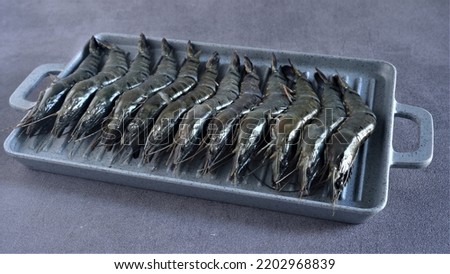 Shrimps. Close view and Selective Focus on Fresh Raw Shrimp or Prawn in grey square tray with grey background. Vaname. Litopenaeus vannamei. Black Tiger Shrimp. Protein. Udang Windu. Seafood.