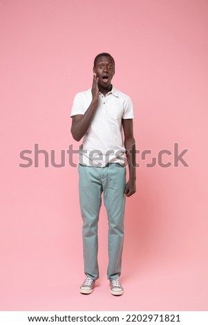 Full length vertical photo of shocked amazed surprised young man 20s he wear white shirt blue trousers put hand on cheek isolated on plain pastel light pink background studio. People lifestyle concept Royalty-Free Stock Photo #2202971821