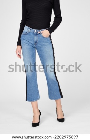 Women's flared cropped jeans on model isolated on white background. Woman wearing blue denim jeans, heels, autumn spring outfit. Top view. Template, mock up Royalty-Free Stock Photo #2202975897