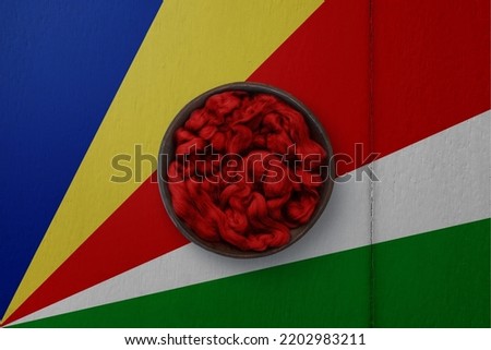Wooden basket on background in colors of national flag. Photography and marketing digital backdrop. Seychelles