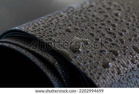 Water droplets on the rubber membrane. Waterproofing...  Close-up selective focus area. Royalty-Free Stock Photo #2202994699