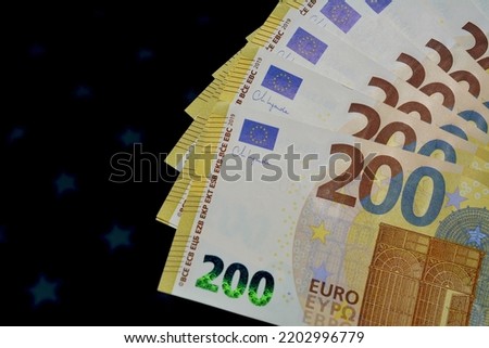 European cash. 200 euro bills on a black background.