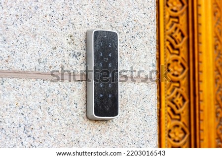 Black metal electric code lock with the digital keypad and card access near the house entrance door Royalty-Free Stock Photo #2203016543