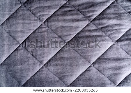 Grey blue weighted blanket texture detail, heavy padded relaxing bed sheet cover filled with glass beads Royalty-Free Stock Photo #2203035265