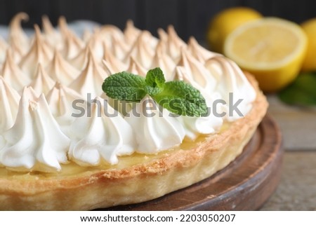 Delicious lemon meringue pie decorated with mint on table, closeup