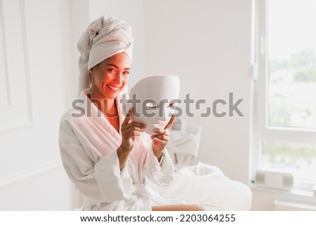 Beautiful young woman getting a led light therapy mask treatment  for her face at the beauty salon. Royalty-Free Stock Photo #2203064255