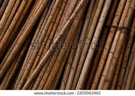 Photo of a pile of orange and brown wooden sticks, close up the background.
