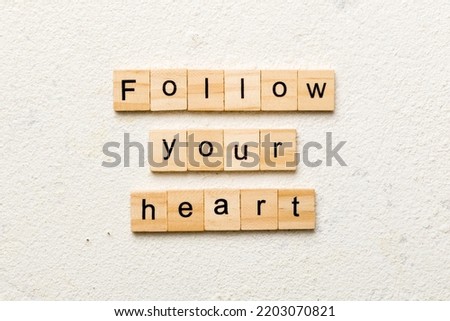 Follow your heart word written on wood block. Follow your heart text on cement table for your desing, Top view concept.