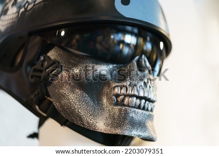 Photography of mock-up of gray metallic skull indoor. Sport helmet on the head. Symbol of death and halloween.
