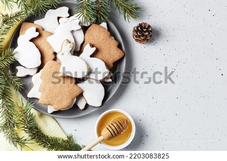 Delicious homemade Christmas cookies in the shape of a rabbit and a Christmas tree on a gray background decorated with New Year's decor. copy space