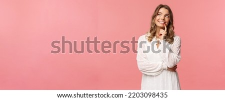 Beauty, fashion and women concept. Portrait of feminine, beautiful blond girl in white dress, imaging something romantic and interesting, smiling look up thoughtful, have plan, make decision