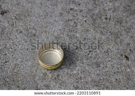 gold bottle cap lid on ground
