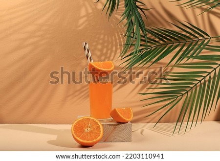 Modern still life with citrus fruits, orange juice and oranges on a pastel background with long hard shadows, minimal detox diet concept, summer vitamin drinks, selective focus, space for text