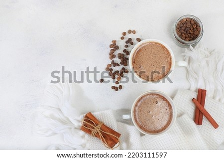 Cozy home table with cappuccino coffee, cinnamon coffee beans, healthy breakfast with ingredients, hello autumn concept, hygge style, modern coffee shop advertisement, selective focus