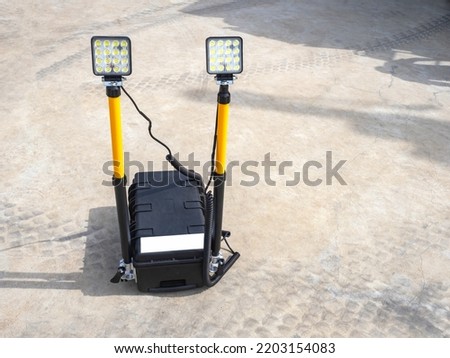 Lighting equipment. Mobile floodlights for exposure illumination. Dual LED spotlight on ground. Case with LED elements. Mobile floodlights in open air. Searchlight equipment sale concept Royalty-Free Stock Photo #2203154083