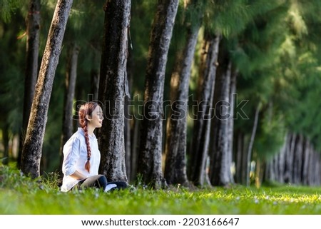 Woman relaxingly practicing meditation in the pine forest to attain happiness from inner peace wisdom for healthy mind and soul Royalty-Free Stock Photo #2203166647