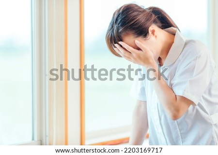 Depressed nurse Asian woman (worry, pain) Royalty-Free Stock Photo #2203169717